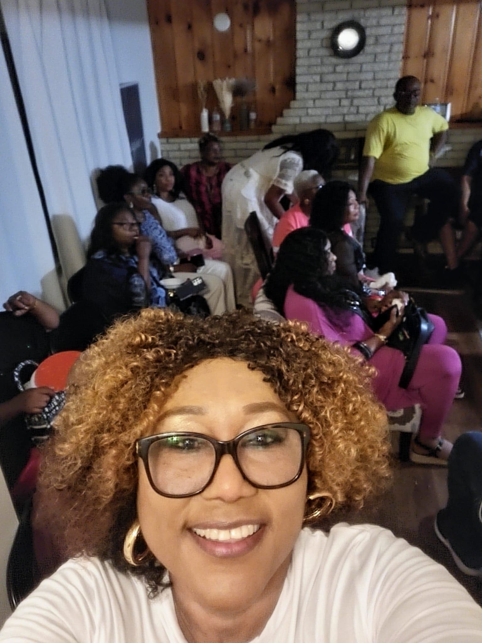 A woman taking a selfie with fellow members behind her