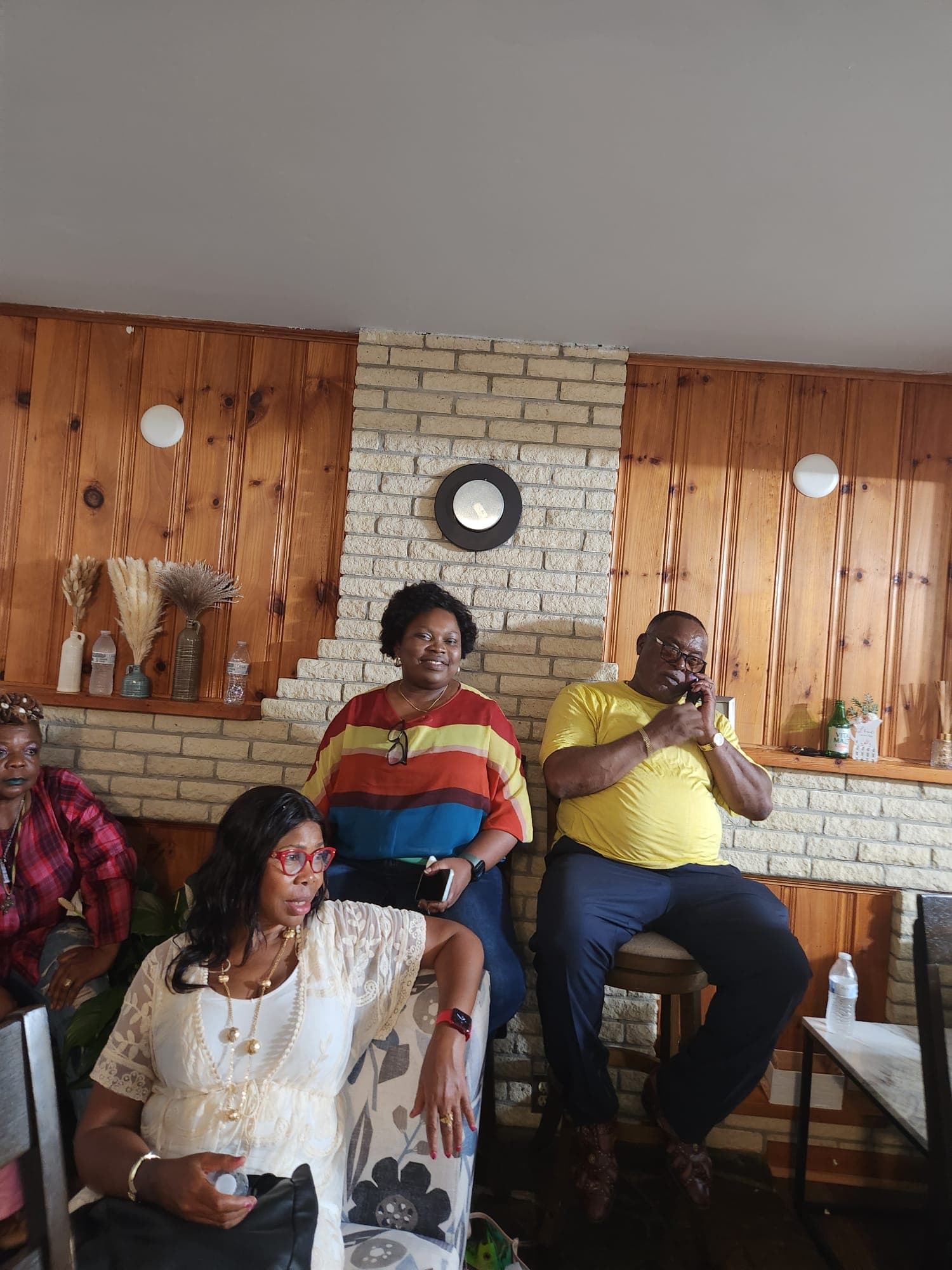 Members seated along a wood-panelled wall